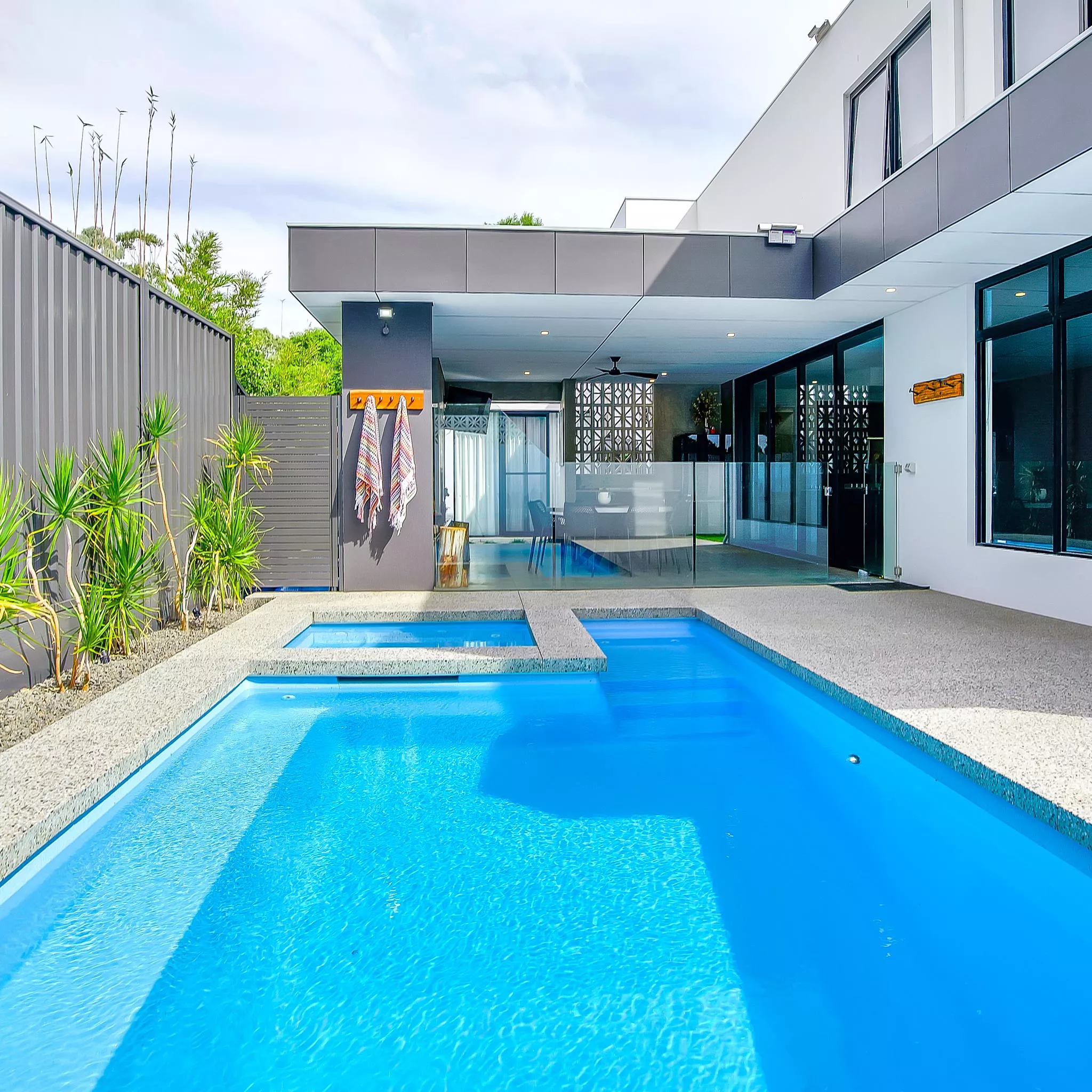 Fibreglass pool with smooth finish surrounded by stone paving